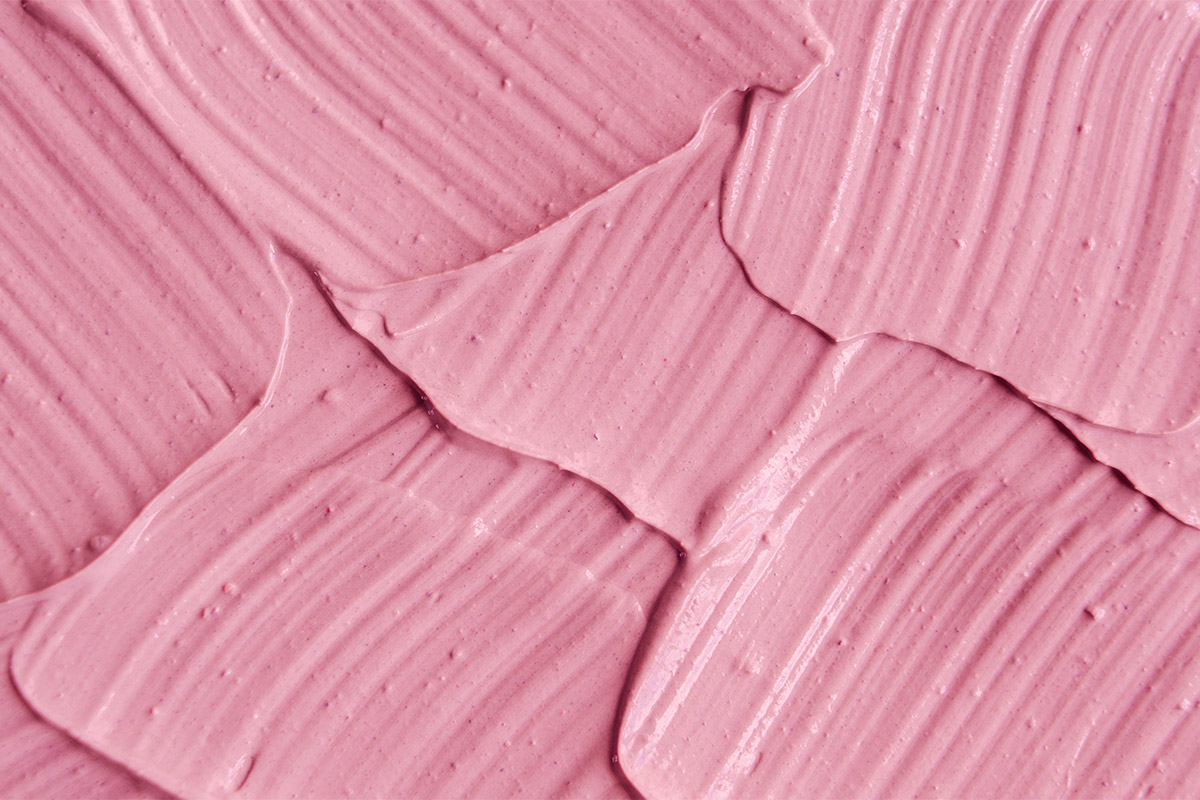 粉红色化妆品粘土（面膜、奶油）质地特写，选择性聚焦。抽象背景
